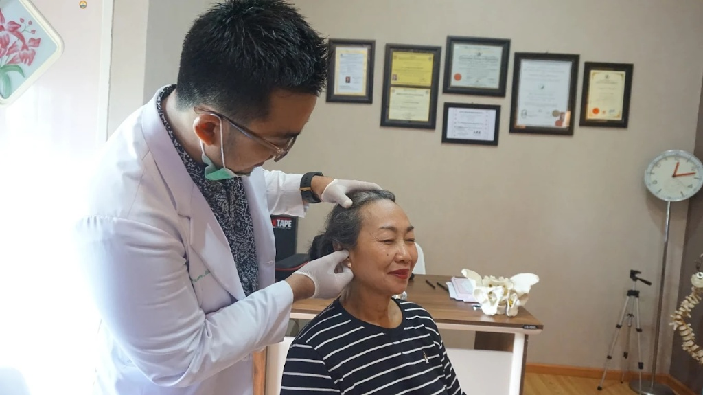 dr. Yusran, Dipl.Ac sedang menangani pasien dengan terapi akupunktur